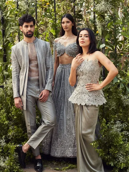 This coordinated group look in shades of grey showcases modern couture. The men's layered outfit with a sheer inner kurta is a daring and sophisticated choice for a fashion forward event.