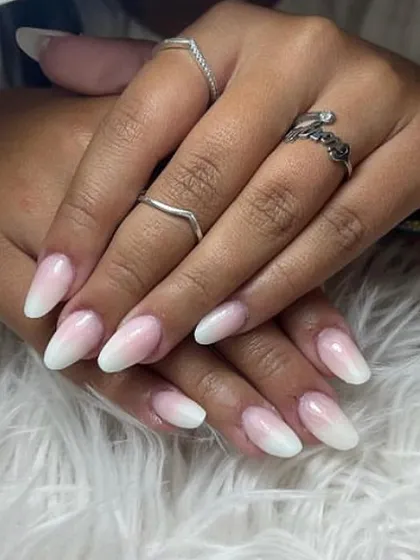 A classic ombré manicure with a soft white tip fading into a natural pink base on almond-shaped nails.