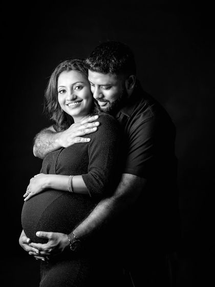 An intimate black and white embrace. This pose, with the partner holding the mom-to-be from behind, feels protective and full of love.