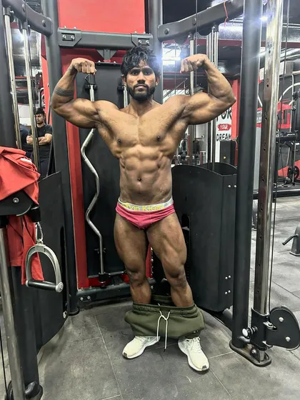 The final condition check before the show. A front double bicep pose, showing the shredded abs and legs.