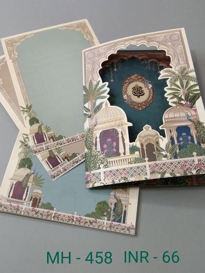 A multi-layered invitation with a die-cut window revealing a beautiful palace scene. The teal and green color palette is refreshing, and the card includes three inserts.