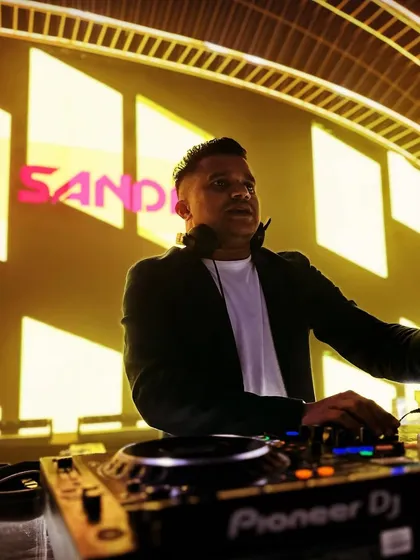 A portrait from behind the decks, with my name lit up in the background. This shot captures my confidence and experience, earned over 18 years in the industry.