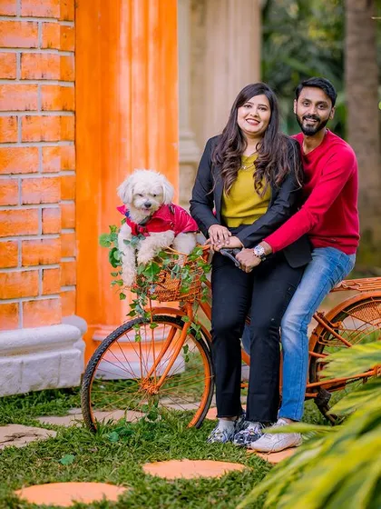 A couple with their dog in a bicycle basket, a fun and charming photo idea.