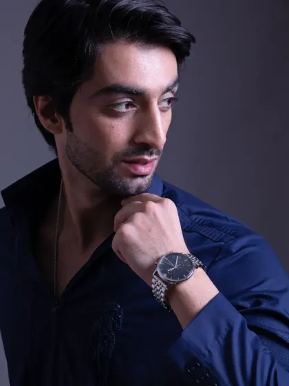 A close-up of the navy zip-front shirt, showing the detail on the collar and the sheen of the fabric.