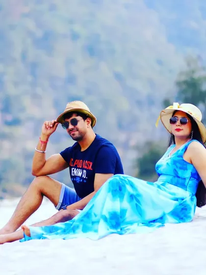 A relaxed portrait from a beach-themed pre-wedding shoot. The couple's coordinated hats and casual poses give this shot a fun, vacation-like vibe.