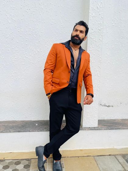 A stylish pose in the burnt orange blazer. This custom piece is designed to stand out and gives a very sharp, modern vibe.