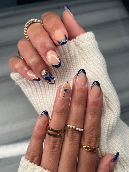 This angle highlights the different hand-painted details, including the delicate star on one nail and the abstract design on another. It's all about creating a unique story.