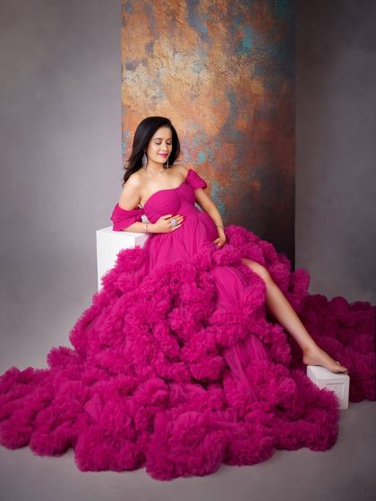 A gentle, loving pose cradling the baby bump. The sheer volume and vibrant color of this magenta gown make it a truly unforgettable piece from my collection.