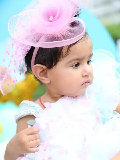 A profile shot of the little girl in her party outfit and fascinator hat. Even the quiet, thoughtful expressions are beautiful to capture during a busy birthday celebration.