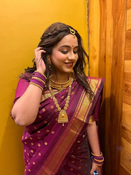 The complete look for Vishakha, featuring a beautiful purple saree and gold jewelry. The makeup is natural and enhances her youthful glow.