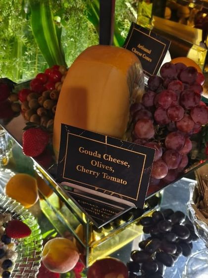 A block of aged Gouda cheese, ready to be carved and served as part of an artisanal cheese platter. This is a staple of our elegant winter spreads.