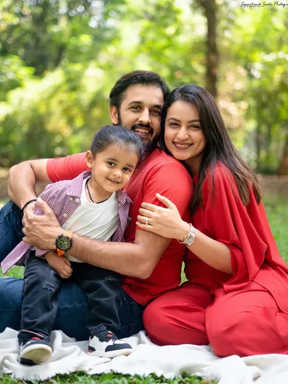 A beautiful, warm hug during an outdoor family session. The lush green background and natural sunlight create a perfect setting for this loving family portrait.