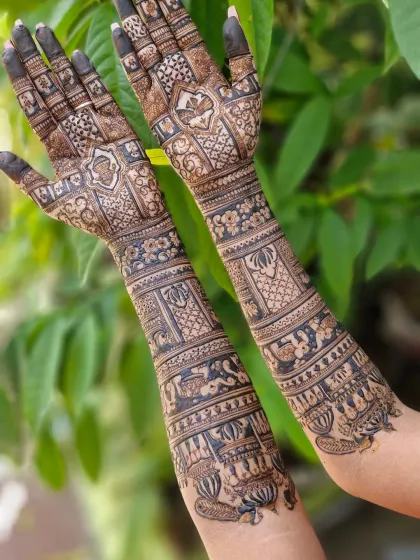 A reverse view of the full-arm bridal mehendi, showing the intricate patterns on the back of the hands and arms.