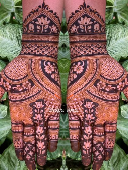 A very dense and intricate design with floral and paisley elements, covering the entire hand.