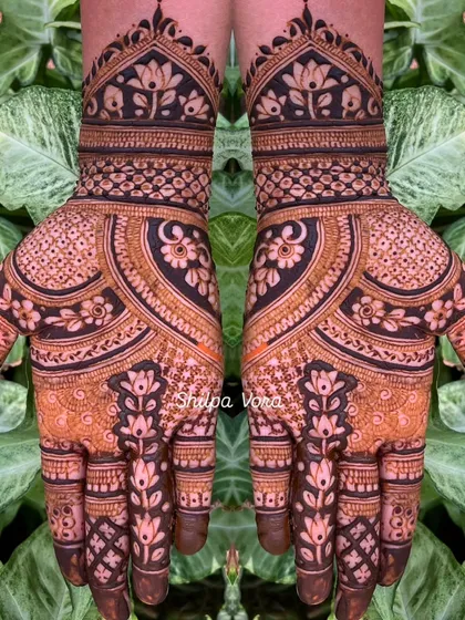 A very dense and intricate design with floral and paisley elements, covering the entire hand.