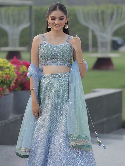 A happy and candid shot in the ice blue lehenga. This is the perfect outfit for creating beautiful memories at any special occasion.
