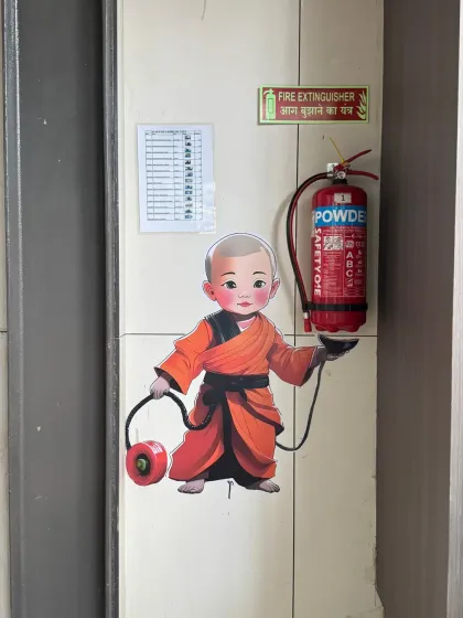 Another example of integrating safety equipment into the decor. This mural shows a little monk holding a fire extinguisher, adding a touch of whimsy to a functional item and making the space feel more thoughtful.