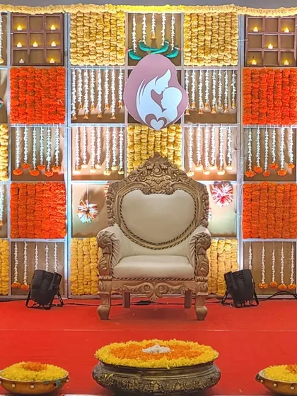 For this Seemantha function, I designed a backdrop with panels of bright orange and yellow marigolds. A central mother-and-child motif and a traditional carved throne complete this vibrant and auspicious setting.