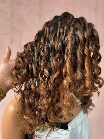 Caramel kissed curlylocks. These beautiful curls are enhanced with warm, caramel tones using a non-bleach formula for a healthy, glossy finish.