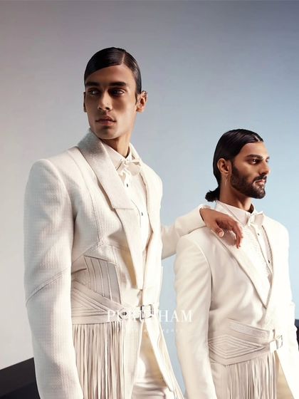 Another perspective on the modern white suits, showing how the structured and fringed elements create a powerful visual dialogue. This is refined elegance for today.