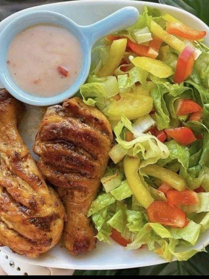 A balanced meal of grilled chicken drumsticks with a side of fresh, crunchy salad. A great option for a casual lunch or dinner event.