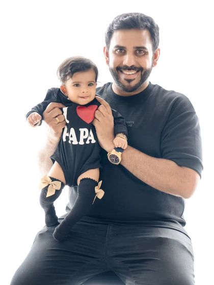Daddy's little girl. A heartwarming portrait of a father holding his baby, who is wearing an adorable "I ❤️ Papa" onesie.