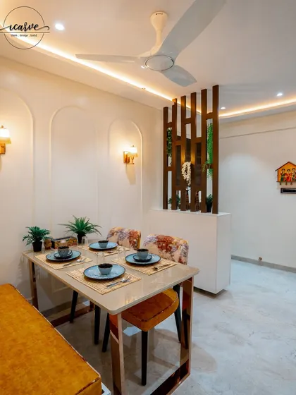 This dining area features a mix of seating with a bench and chairs, perfect for families. A wooden partition with planters adds a touch of green and subtly separates the dining space from the living area.