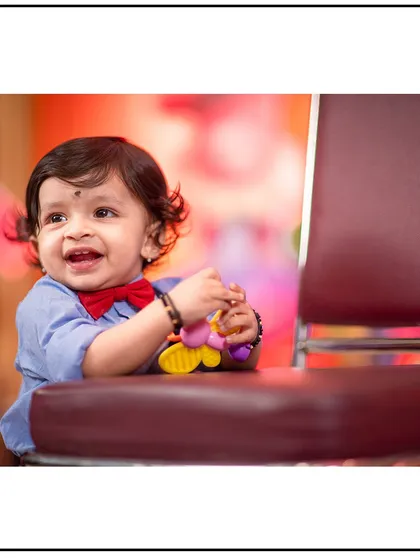A joyful smile captured during an indoor portrait session. The soft, colorful background adds a cheerful feel to the image.
