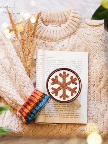 A cozy winter flatlay featuring a warm sweater, a book, and a cup of hot cocoa. This type of styled shot is perfect for creating a seasonal mood for a brand or product.