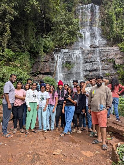 Our group posing in front of Hebbe falls during an Explore Chikmagalur trip, a must-see spot.