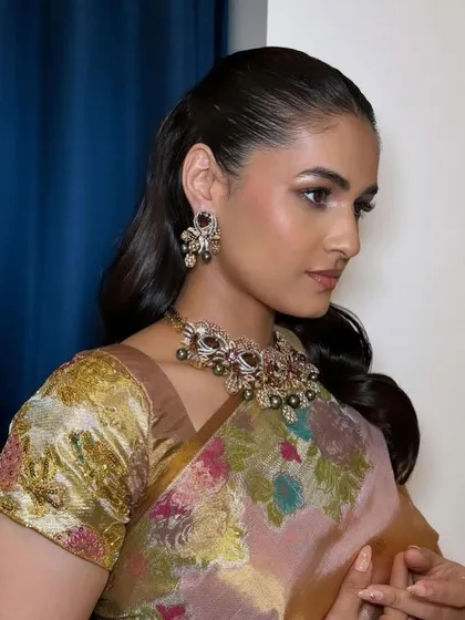 A wet-look, sleek ponytail for a modern and high-fashion statement, perfect for a cocktail party or a contemporary event.