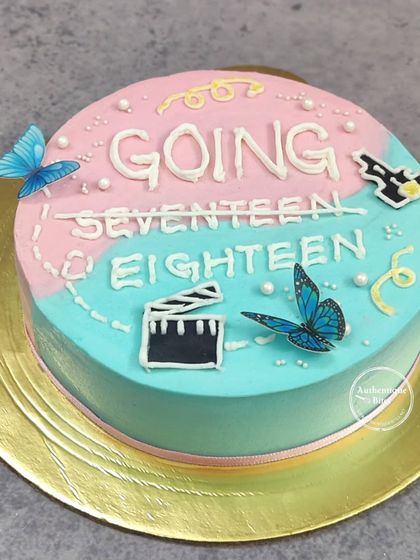 A K-Pop inspired "Going Seventeen" cake. The pink and blue design with movie clapper and butterfly details is perfect for a fan's 18th birthday.