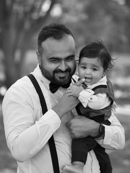 A playful and happy moment between a father and his baby. The black and white edit focuses on their joyful expressions and connection.