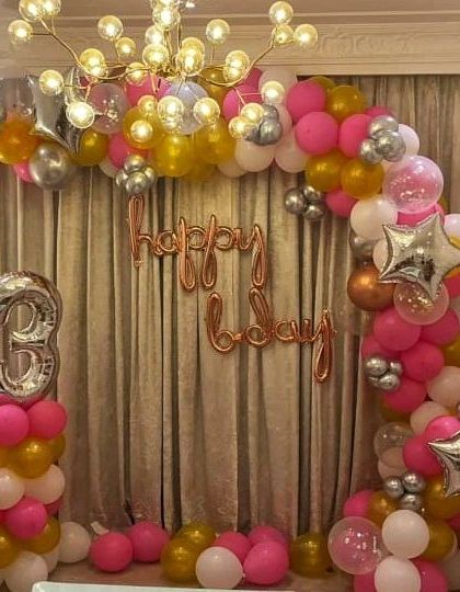 This vibrant balloon arch in shades of pink, gold, and white is perfect for a lively celebration. The large '3' foil balloon and star accents make it a fun and festive backdrop for a third birthday party.