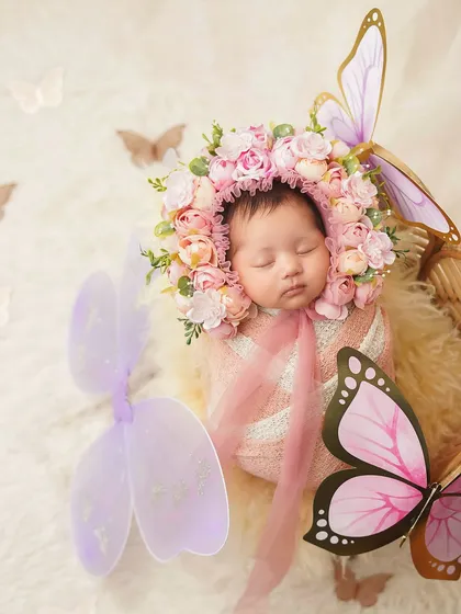 A newborn girl transformed into a beautiful butterfly, with a stunning floral bonnet and decorative wings. This is a truly magical and whimsical theme.
