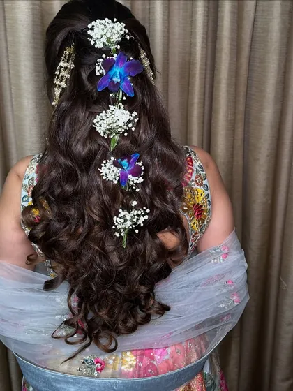 A beautiful hairstyle is the crown on a bridal look. My talented hair team created this intricate braided style with fresh baby's breath and orchids for a romantic and unique touch.