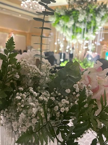 A close-up of a table centerpiece, with the Wish Tree blurred in the background. This shows how we carry the decor theme through to every detail of the event.