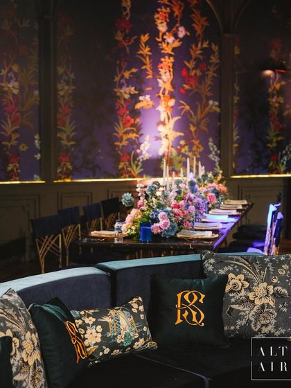 A lounge area at 'Midnight Mirage', with custom monogrammed pillows and floral-printed textiles. The design was inspired by cobalt's deep hues and nature's allure.