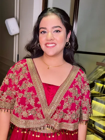 A happy and smiling guest, looking beautiful in her red and gold outfit.