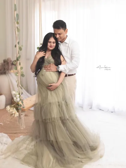 A tender couple's portrait on our popular boho swing set. The olive green tiered gown is a client favorite, and this image captures the loving connection between the parents-to-be.