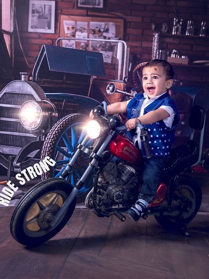 Ride strong, little one. The joy on this baby's face is infectious as he enjoys his turn on the mini-bike, with the headlights adding a dramatic flair.