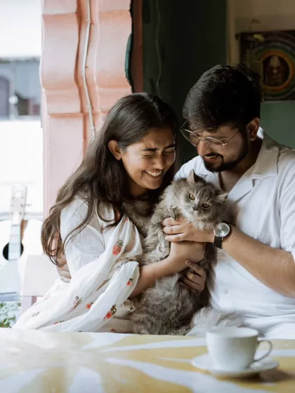 A happy, candid moment of the couple and their cat, capturing the pure joy and love in their cozy, intimate setting.