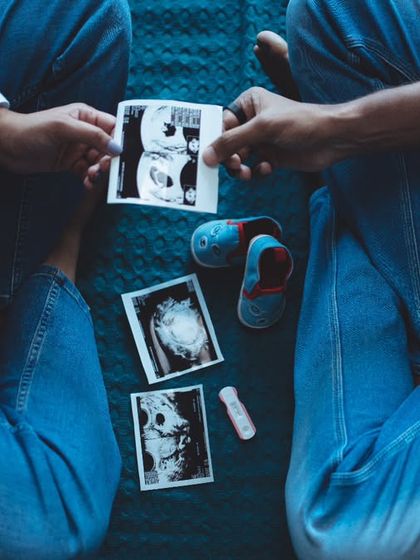 Another perspective on the creative flat-lay announcement. This top-down view captures the couple's hands, the ultrasound, and baby shoes, creating a beautiful and detailed snapshot of their excitement.
