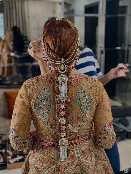 This shot shows the full length of the heavily accessorized braid, a true masterpiece for a royal bridal look.