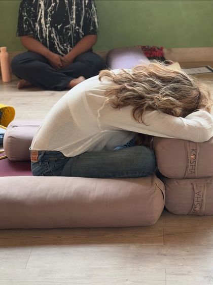 A participant finds a comfortable and restorative posture using our studio props during a journaling workshop, showing how we prioritize physical ease to aid mental clarity.