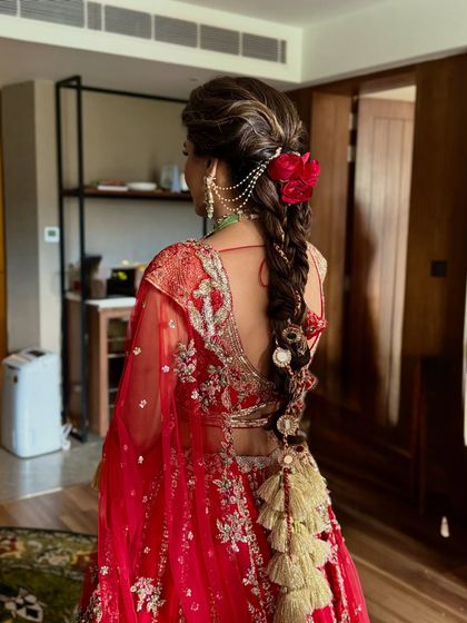 A side view of the traditional bridal braid, showing how the red roses and hair chain are placed to complement the bride's profile.