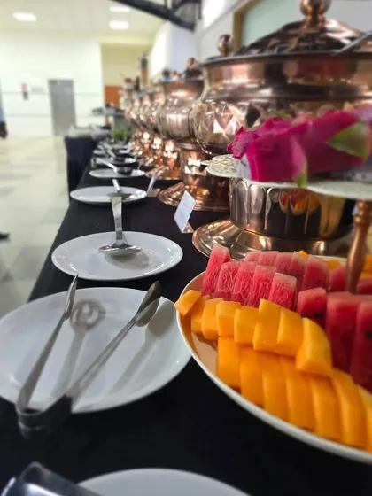A close-up of our buffet line, showing a fresh fruit platter alongside our hot dishes. We always include healthy and refreshing options in our menus.