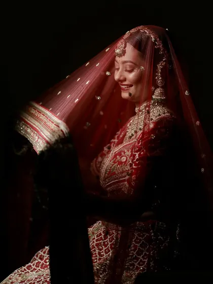 A candid moment of joy. Krupa's smile shines through her veil, showcasing how a well-executed makeup look can make a bride feel confident and happy.