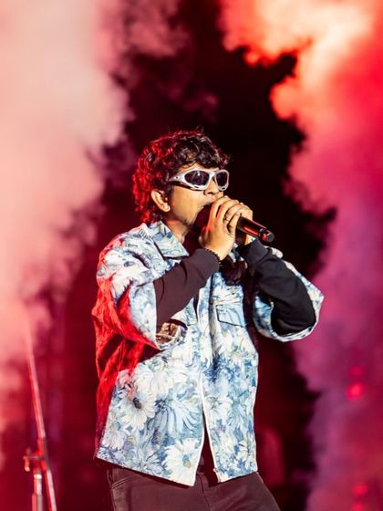 An artist surrounded by a cloud of red smoke, a signature visual effect. I use atmospheric effects like colored smoke and haze to build drama and create a cinematic feel on stage.