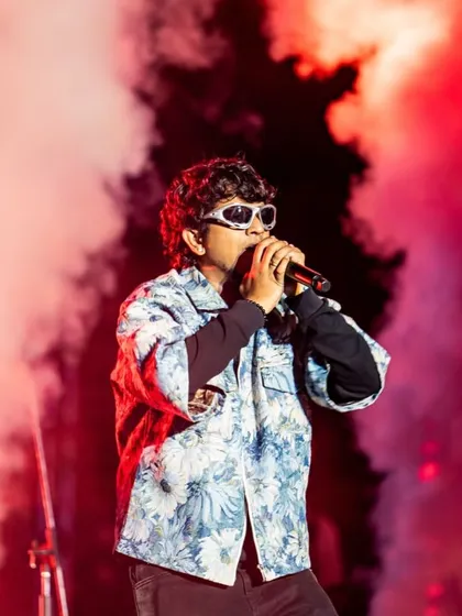 An artist surrounded by a cloud of red smoke, a signature visual effect. I use atmospheric effects like colored smoke and haze to build drama and create a cinematic feel on stage.